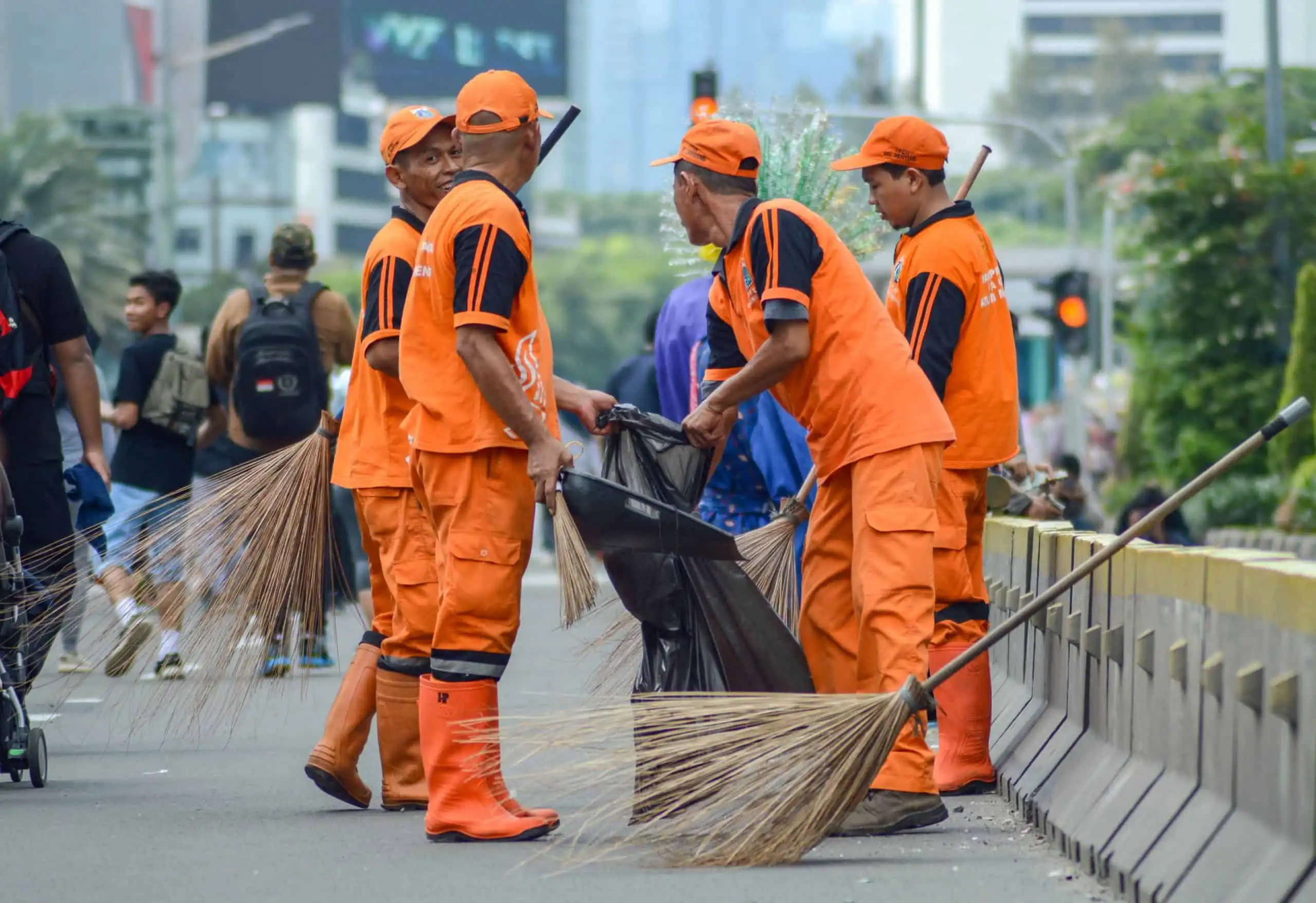 In Indonesia a group of street cleaners in orange uniforms 