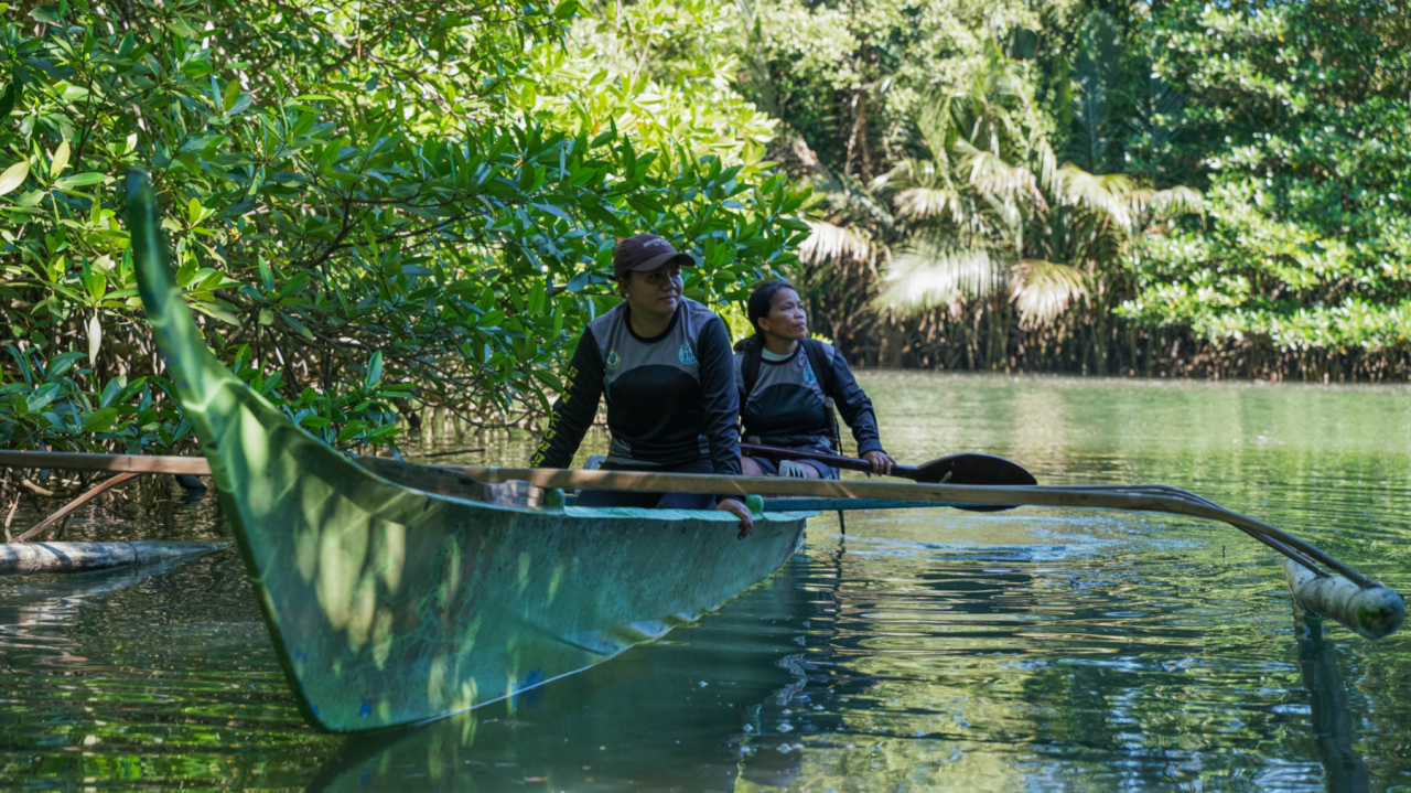 Eliza and Vilma navigating mangroves on a small boat