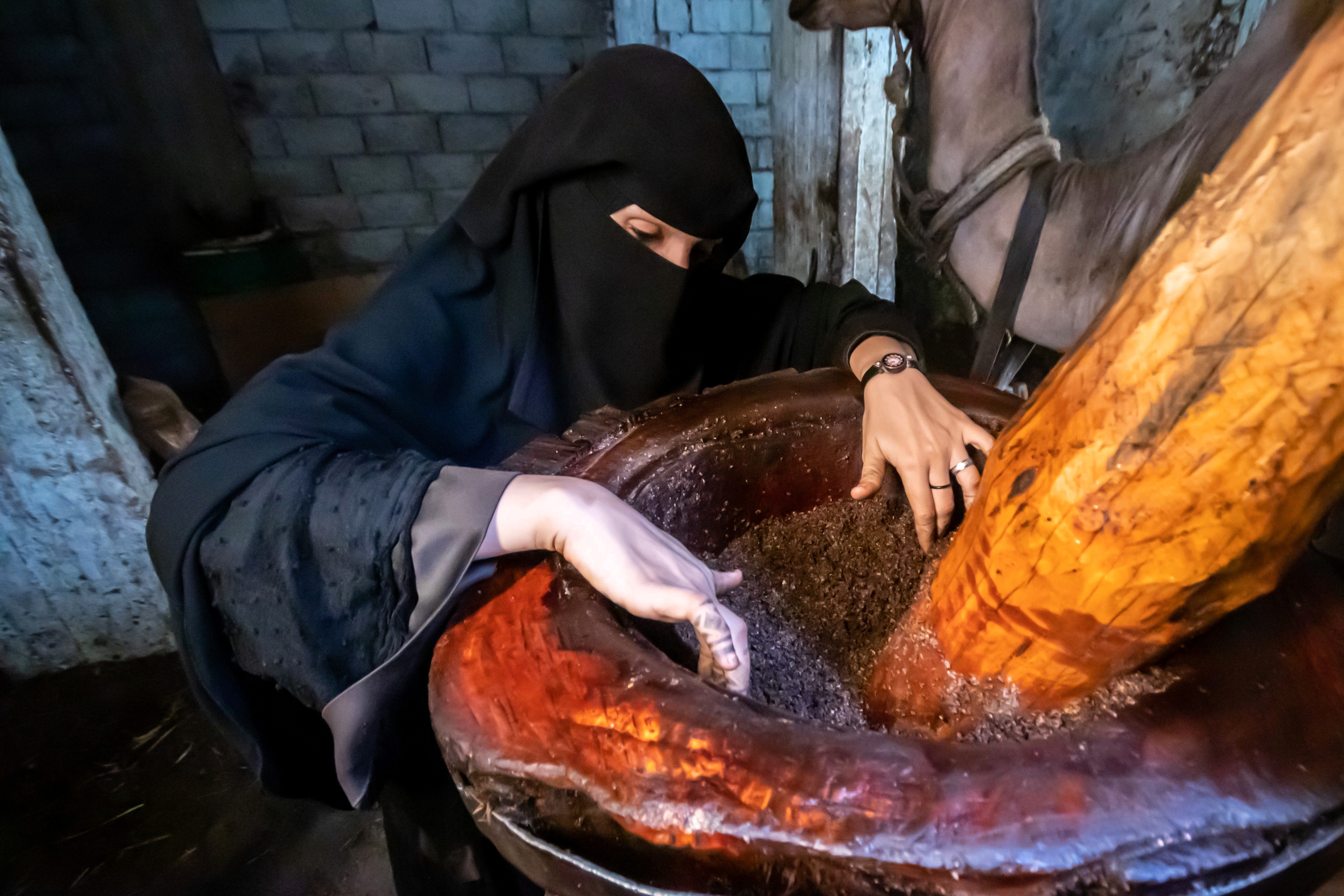 Ashjan prepares the raw sesame to be milled.