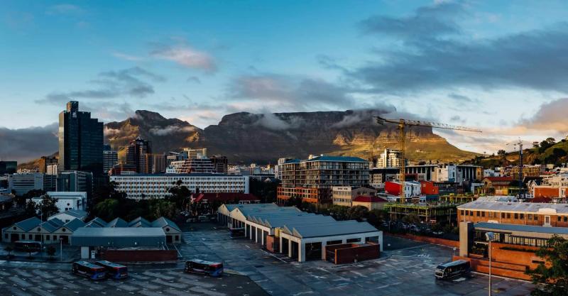 page_news_pic_18_oct_2023 a city with a view on an industrial complex with bus depot and mountains in background