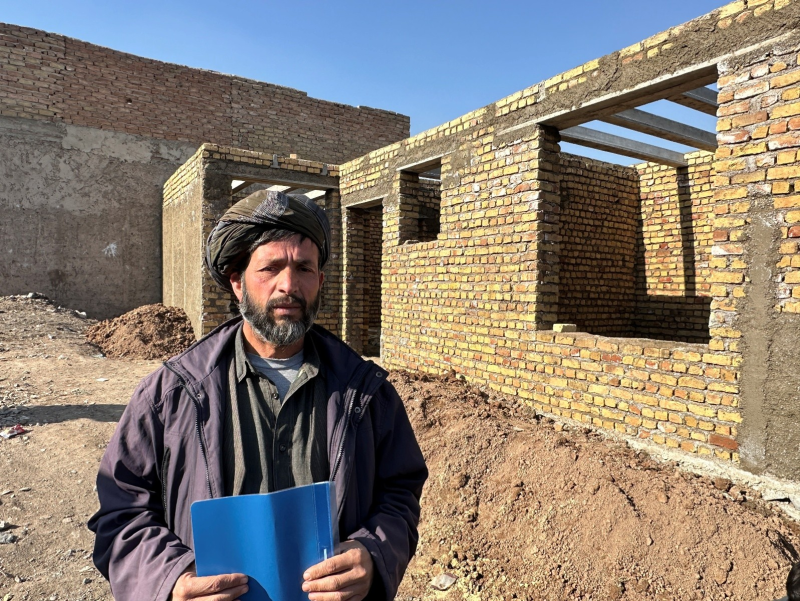Nasser Mohammadi in front of his new home under construction in Herat Province